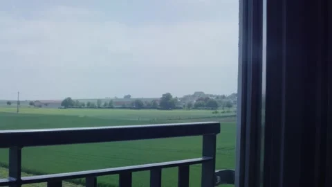 View From Balcony Over Green Fields, Village on Horizon, Wide Shot Video stock 341422903