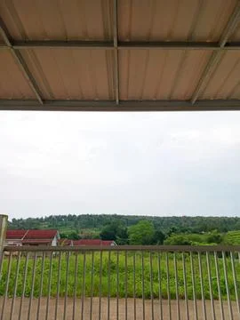 View from a balcony overlooking green fields and trees Stock Photos