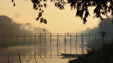 View of a bamboo bridge over a river at sunrise, Bangladesh. 스톡 동영상 335614433
