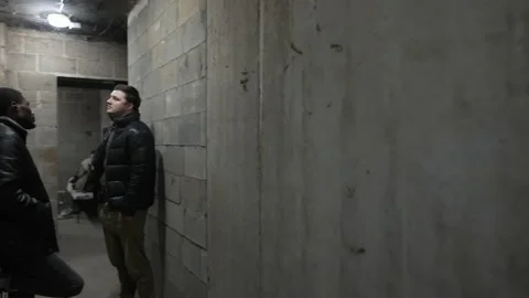 View of a basement with caucasian guy and black guy having a talk during a Stock-Footage 171346629