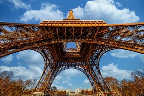 Up view at the basement of the Eiffel tower under a sunny cloudy summer sky,  Foto stock