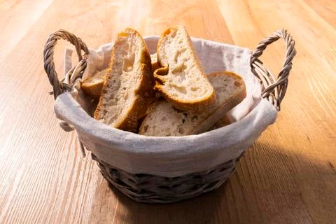 View of a basket full of bread slices on a wooden table. Traditional and heal Stock Photos