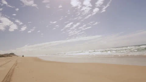 View of a beach and ocean with an ATV in the distance in Australia with bright n Stock Footage 199458148
