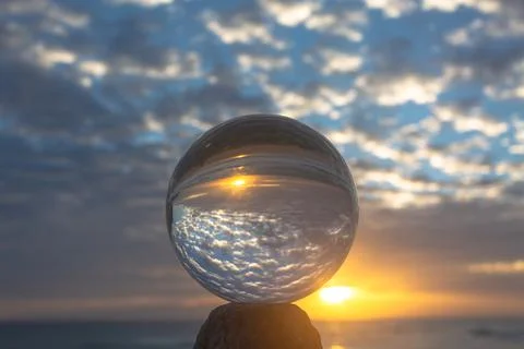 View of the beach in beautiful sunset inside crystal ball. Stock Photos