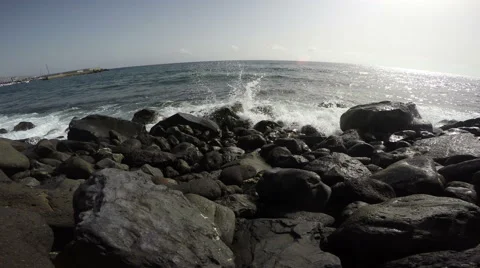 View of beach with big black lava stones by ocean, 4K Stock Footage 58660347