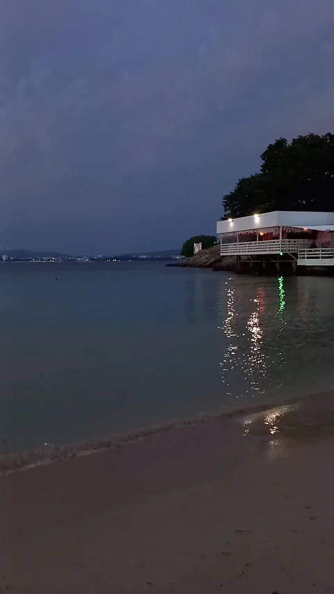 View of beach cafe with lights in late evening. 스톡 동영상 279773780