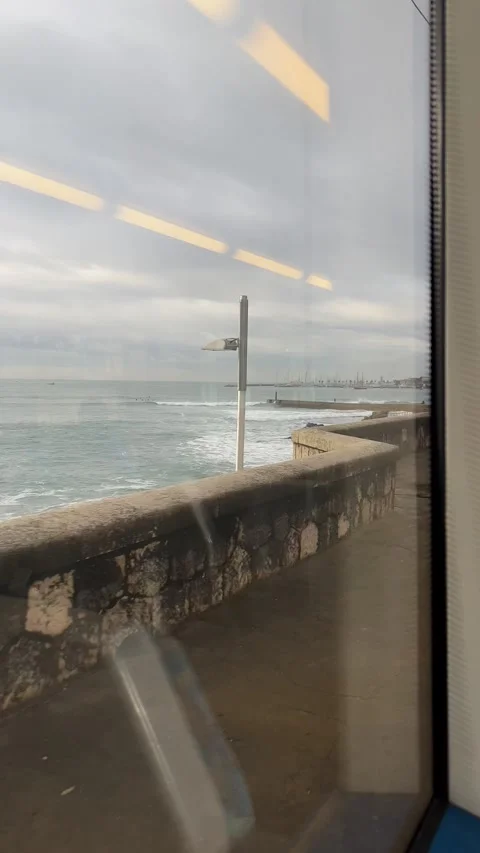 View of beach in Cascais in winter from train window. Vertical video Stock Footage 241023729