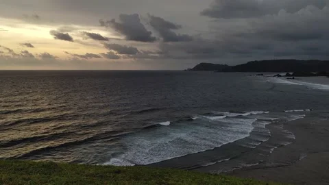 View of the beach in the evening with the sun setting on the open ocean Stock Footage 226607819