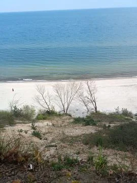 A view of a beach from a hill overlooking the ocean 스톡 사진