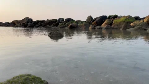 View of the beach with large rocks in the background Stock Footage 286854353