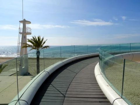 View of the beach with lifeguard tower and glass walkway in Alicante city Stock Photos
