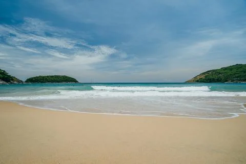 View of the beach with waves surrounded by green hills and white sand, turquoise Stock Photos