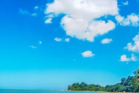 The view of the beach with white clouds and a clear and beautiful blue sky Stock Photos
