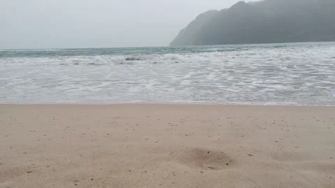 The view of the beach with white sand and the island in front in a drizzling atm Stock Footage 202241817