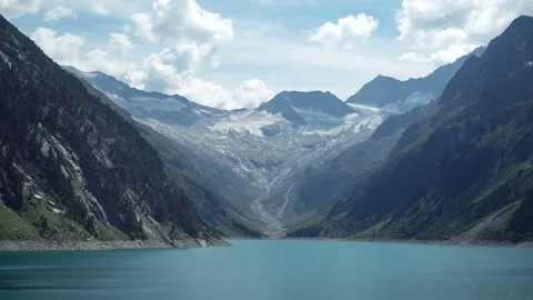 View on beautiful alpine lake surrounded by alps mountains in Austria Stock Footage 121350141