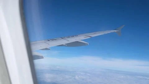 View of beautiful clouds and wing of airplane from window Stock Footage 152966714