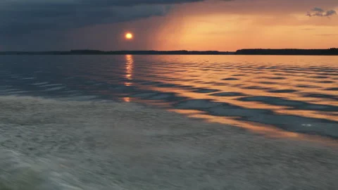 View of a beautiful evening summer sunset through the clouds with the reflection Stock Footage 280547931
