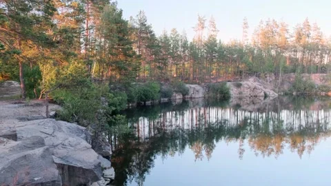 View of a beautiful flooded granite quarry with blue water among a pine forest 動画素材 146082053