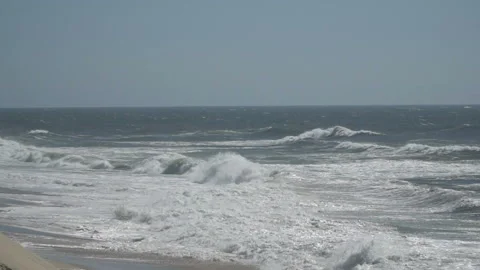 View of a beautiful ocean sandy beach with the blue waves rolling into the shore Stock-Footage 91247393