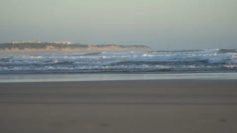 View of a beautiful sandy beach with the blue waves rolling into the shore, some Stock-Footage 91247087