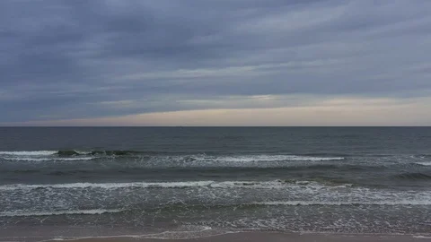 View of a beautiful sandy beach with the blue waves rolling into the shore Stock Footage 116493178