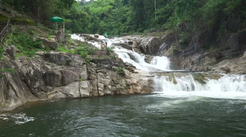 View of beautiful small waterfall in a tropical jungle. Water is falling down to Stock Footage 67536025