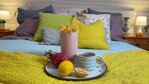 A view of a bedroom interior with a bed covered in bright yellow and blue textil Stock Footage 308234609