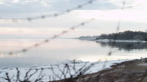 The view from behind barbed wire on the sea cost Stock Footage 61943726