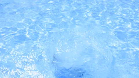 View from behind a brave child in a blue bathing suit diving in a summer pool 스톡 동영상 231423342