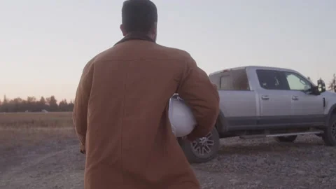 View From Behind of a Farmer Walking Toward His Pickup Truck Stock Footage 217655373