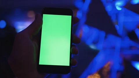 View from behind of hands hold smartphone with vertical green screen among Stock Footage 73840271