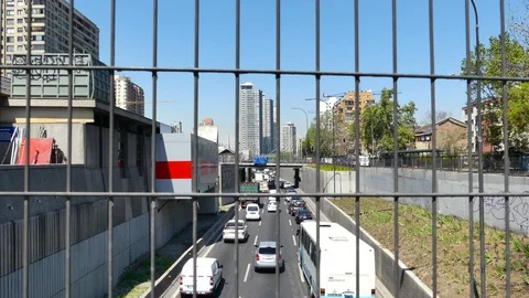 View behind an iron grid of traffic moving along the Autopista Central Stock Footage 98115234