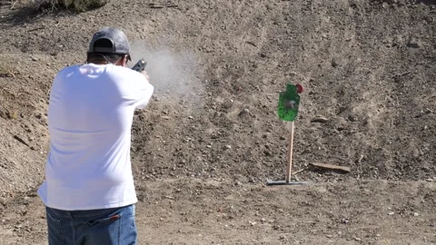 View behind man shooting at a reactive steel Hostage target 스톡 동영상 249016466