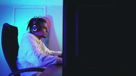 View from behind a personal computer at a focused young gamer Vidéo 144369518