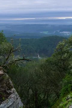 View from behind the rocks and trees to the hills, forests and fields in th.. Stock Photos