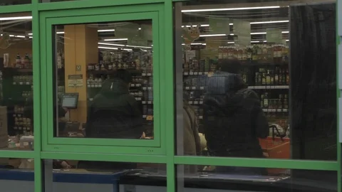 View from behind the shop windows, several people choose products Stock-Footage 106315060