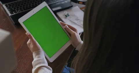 View from behind shoulder of tablet with green screen, girl hold gadget in hands Stock Footage 129840647
