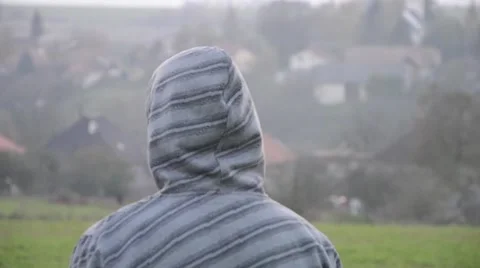 View from behind of young man walking with hooded sweatshirt Stock-Footage 52822239