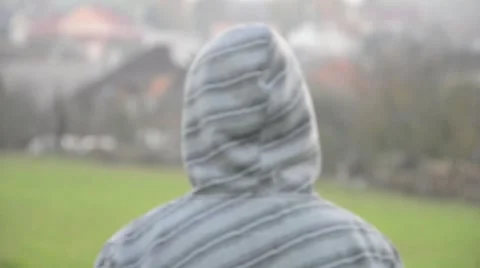 View from behind of young man walking with hooded sweatshirt Stock Footage 52822337