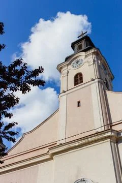 View of the bell tower with clock of Catholic Church with blue sky background. Stock Photos