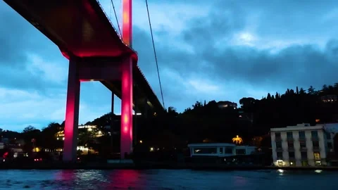 A View from Below of the Bosphorus Bridge Illuminated in Red at Dusk Stock Footage 323135944