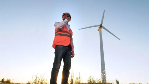 A view from below of a confident male engineer talking on a walkie-talkie and Stock Footage 136237917