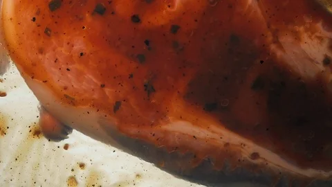 View from below as a cooking brush smears ketchup with herbs for cooking steak Video stock 122646607