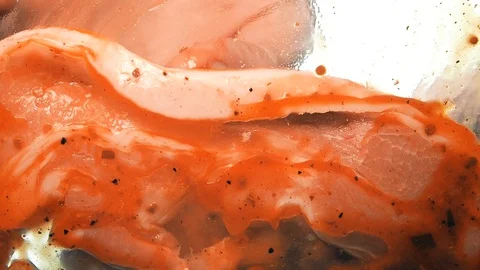 View from below as a cooking brush smears ketchup with herbs for cooking steak Stock Footage 122653776