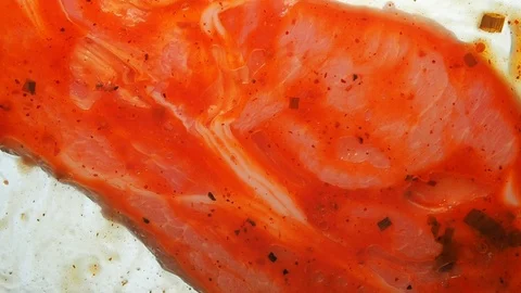 View from below as a cooking brush smears ketchup with herbs for cooking steak Stock Footage 122655091