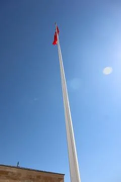 View from below of flag pole with waving red Turkish flag on the sky Stock Photos