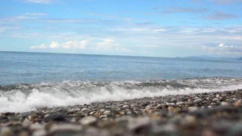 A view from below of the gentle waves rolling onto the pebble beach. Stock-Footage 347963272