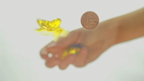 View from below as a hand pours artificial colored starfish. Background for the Stock Footage 122590111