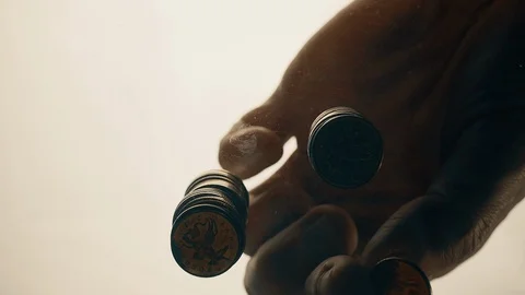 View from below as the hand throws gold coins. Moves them, collects them in the Stock Footage 122609018