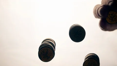 View from below as the hand throws gold coins. Moves them, collects them in the Stock Footage 122609273